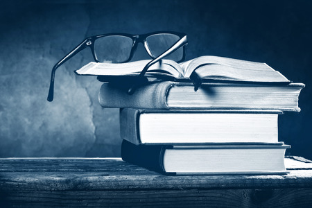 Open book with reading glasses on the dark の写真素材