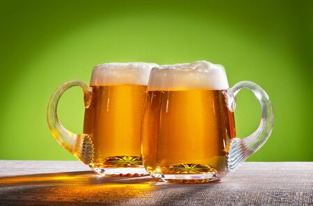 two beers on the table with green backgroundの写真素材