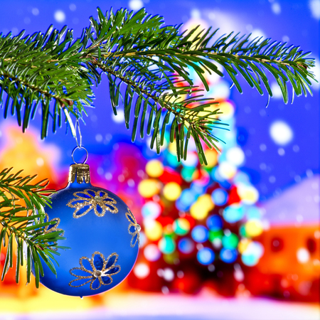 Blue Christmas ball in front of Christmas tree at nightの写真素材