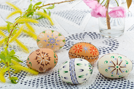 Painted Easter eggs with a blossom on the deskの写真素材