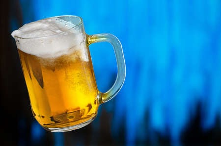 Glass of beer on the blue backgroundの写真素材