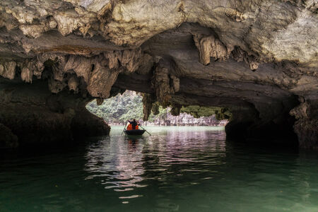 Tourists riding through luon cave in Halong bay.の写真素材