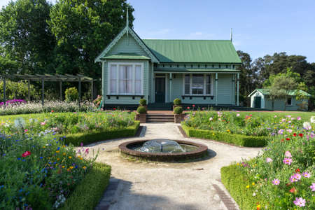 a small green house in rotorua government gardens  with flowers surrounding. Taken in rotorua, new zealand during summer.のeditorial素材