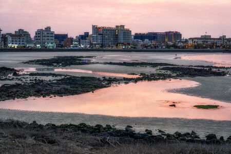 Sunset over the resorts and hotels in Hamdeok Seoubong beach in Jeju Island, South Korea.の写真素材