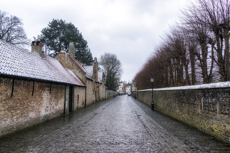 Snow fall over the Bruges cobblestoned alleyway. Bruges, Belgiumの写真素材