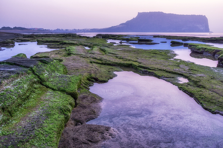 The sunrise view over seongsan ilchulbong on the gwangchigi beach in jeju island, south koreaの写真素材