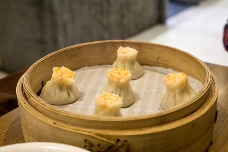shrimp shumai dumpling served on a wooden dumpling plate.の写真素材