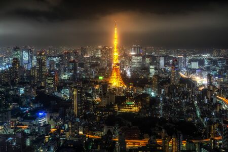 tokyo tower illumianted taken at night with the surrounding city view. Taken from Roppongi hills sky deck in tokyo, japan.のeditorial素材