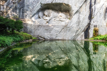 Famous lion monument of Lucerne reflecting on a small pond water. Taken in Lucerne, Switzerlandの写真素材