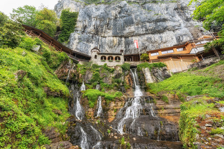 Saint beatus cave entrance and nearby waterfall. Taken in Interlaken, Switzerlandの写真素材