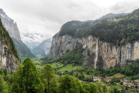 View of Lauterbrunnen village and Staubbach Waterfall. Famous tourist attraction in Bernese Oberland, Switzerlandの写真素材