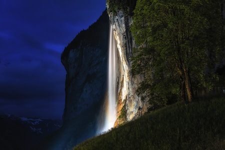 the view of staubbach waterfall at night when it is illuminated. Famous landmark in Lauterbrunnen,...