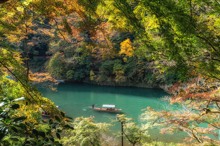 Katsura River boat ride taken during autumn foliage season. boatmen uses long bamboo pole to steer. Taken in Arashiyama, Kyoto, Japanの写真素材
