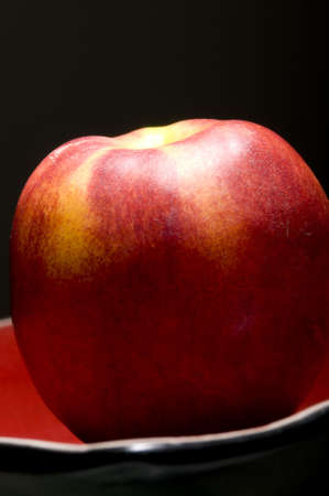 Elegant ripe peach on plate