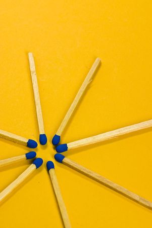 blue matches on yellow backgroundの写真素材