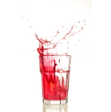 Cocktail splashing on a glass on white backgroundの写真素材