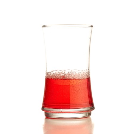 Cocktail splashing on a glass on white background