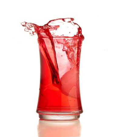 Red cocktail splashing on a glass on white backgroundの写真素材
