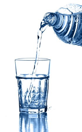 pouring water on a glass on white backgroundの写真素材