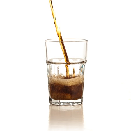 beverage splash into a glass on white backgroundの写真素材
