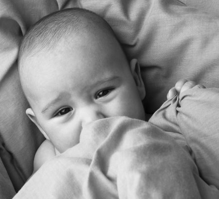 afraid newborn baby resting on a blue blanket closeupの写真素材