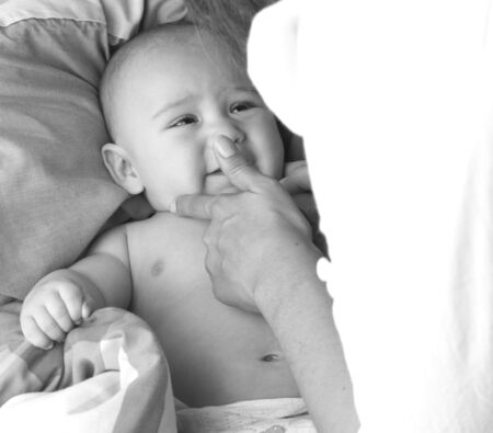 baby on blanket and his mum, closeupの写真素材