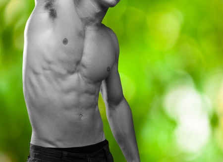strong torso of a young man against a plants background