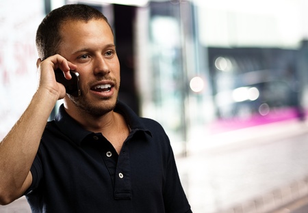 young man wearing polo shirt talking on mobile phone 