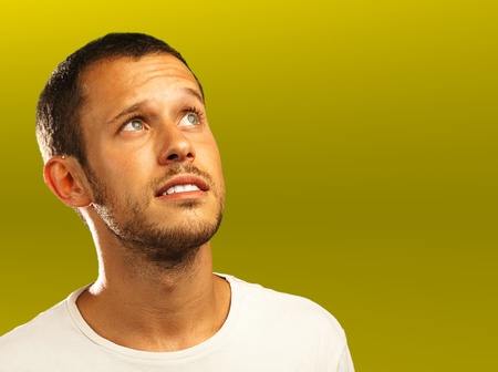 young man thinking on a golden background