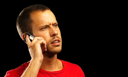 young businessman calling on mobile phone on black backgroundの写真素材