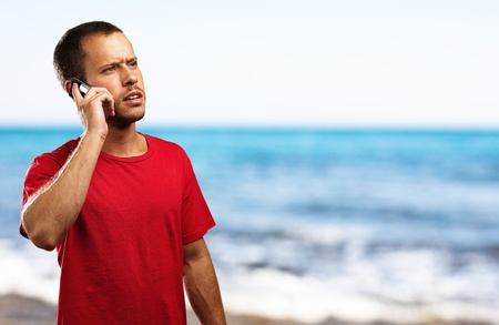 young businessman calling on mobile phone in the beachの写真素材