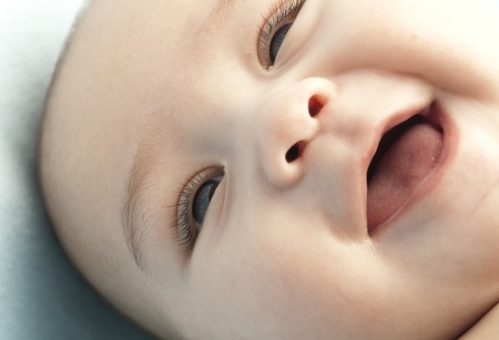 baby with her tongue out on a cotton blanketの写真素材