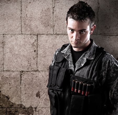 young armed soldier against a grunge background