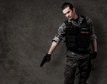 young soldier pointing to the ground againsta a grunge wallの写真素材