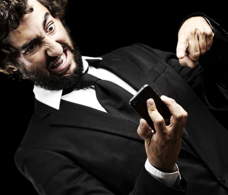 portrait of young business man angry with the technology against a white backgroundの写真素材