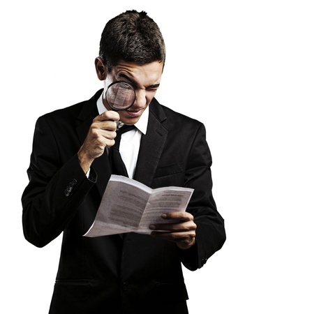 portrait of handsome young man looking a contract through against a white backgroundの写真素材