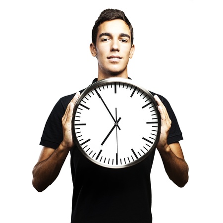 portrait of young man holding a clock with his hands over white backgroundの写真素材