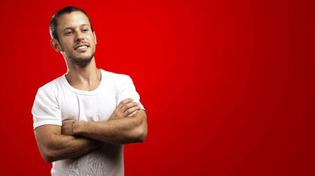 young man with crossed arms on a black backgroundの写真素材