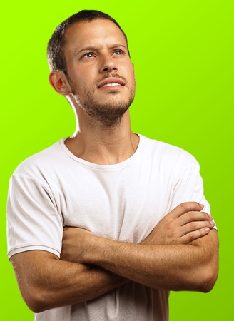 young man looking up and thinking about the future on a green backgroundの写真素材