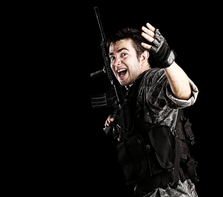 portrait of young soldier telling that follow him against black background