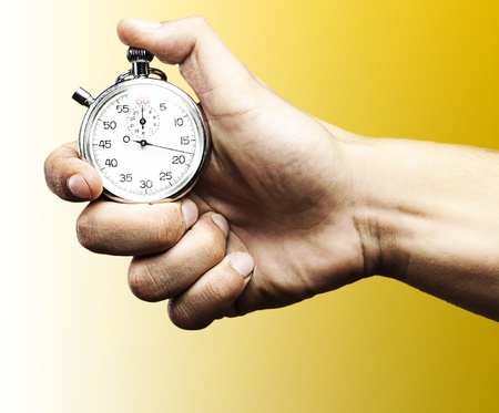 hand holding a stopwatch against a blue backgroundの写真素材
