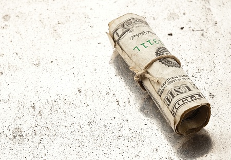 rolled dollar on metal surface