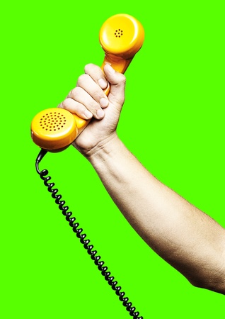 man giving a vintage telephone against a removable chroma key backgroundの写真素材