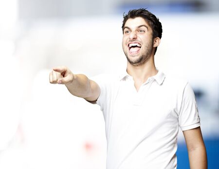 portrait of young man pointing and joking against a abstract backgroundの写真素材