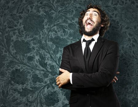 portrait of young man laughing against a grunge wallの写真素材