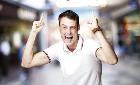 portrait of young man pointing up at crowded placeの写真素材