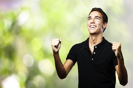 portrait of young man winning against a nature backgroundの写真素材