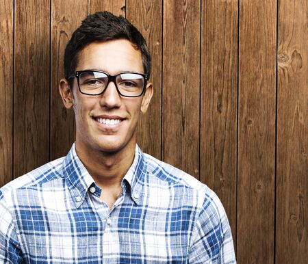 portrait of young man smiling against a wooden wallの写真素材
