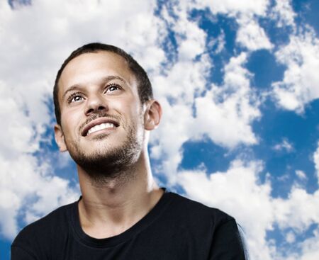 young man smiling on a blue sky background