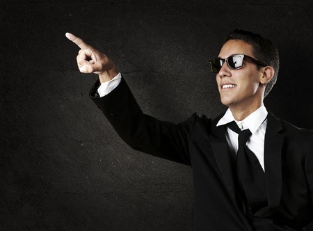portrait of young business man pointing up against a grunge backgroundの写真素材